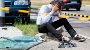 Accident victims gathered on an accident spot with a broken car in the background